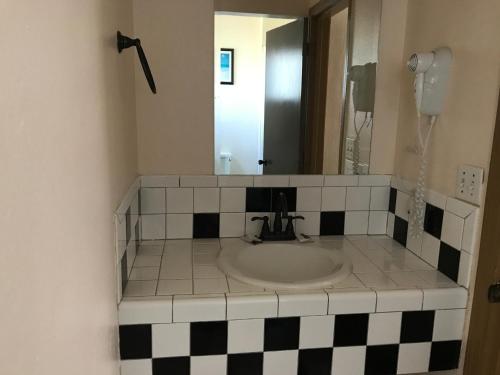 a bathroom with a sink and a mirror at Westwind Lodge in Oakland