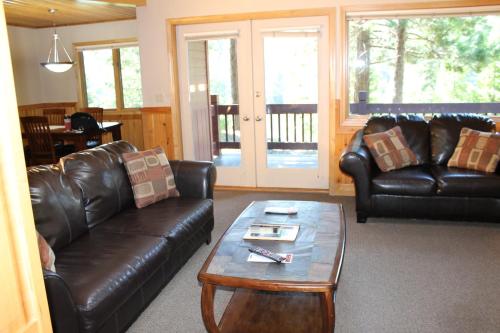 a living room with two leather couches and a coffee table at Mount Shasta Resort in Mount Shasta
