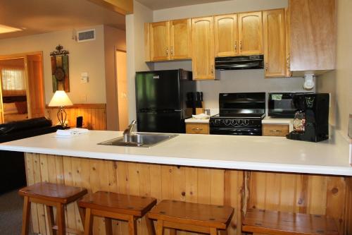 a kitchen with a sink and a counter with chairs at Mount Shasta Resort in Mount Shasta
