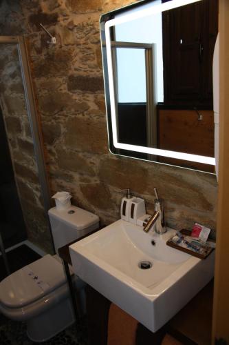 a bathroom with a sink and a mirror and a toilet at Alojamiento Luz de Hadas in Sampil