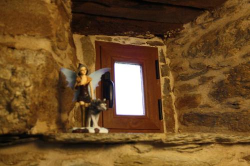 a window in a stone wall with a statue of a woman at Alojamiento Luz de Hadas in Sampil