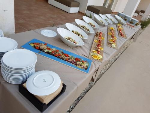 a table with plates and bowls of food on it at Resort Il Mulino in Favignana