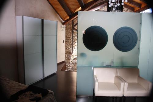 a room with a white chair and a glass wall at Alojamiento Luz de Hadas in Sampil