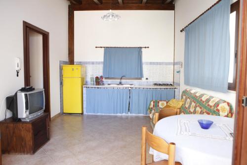 ein Wohnzimmer mit einem Tisch und einem TV in der Unterkunft Ciclamino in Alcamo Marina
