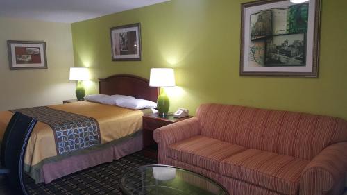 a hotel room with a bed and a couch at American Inn Columbia in Columbia