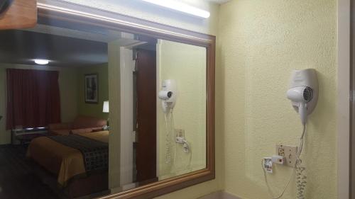 a mirror in a hotel room with a hair dryer at American Inn Columbia in Columbia