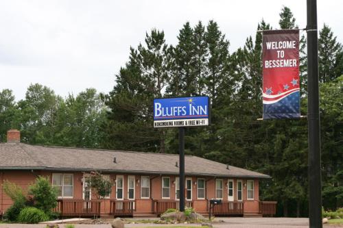 un cartel frente a un edificio con una posada blueuds en Bluffs Inn, en Bessemer