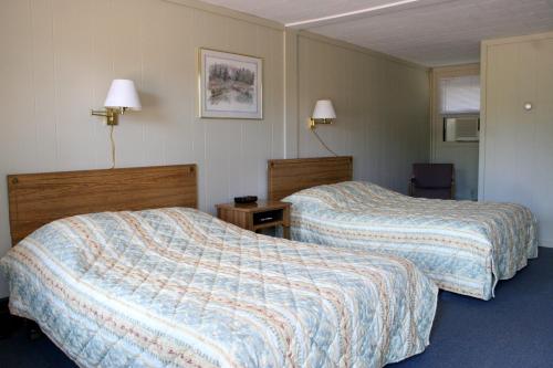 une chambre d'hôtel avec deux lits et une chaise dans l'établissement Bluffs Inn, à Bessemer