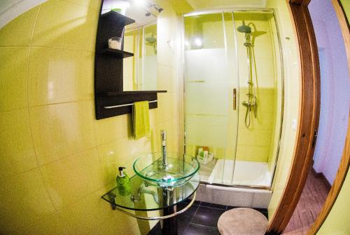 uma casa de banho com uma mesa de vidro e um chuveiro em Belém Apartment em Lisboa