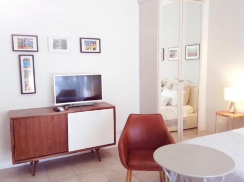 ミラノにあるAngela's Apartmentのベッドルーム(ベッド1台、テレビ、椅子付)