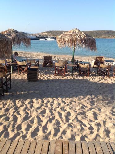 a beach with chairs and umbrellas on the sand at Astarte Sea Villas in Dhiakofti