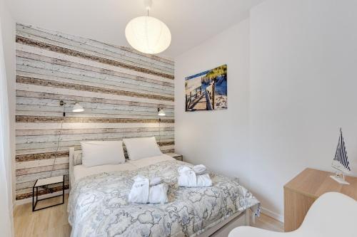 ソポトにあるLion Apartments - La Playaの木製の壁のベッドルーム1室(ベッド1台付)