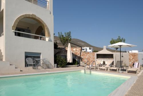 a swimming pool in front of a house at Astarte Sea Villas in Dhiakofti