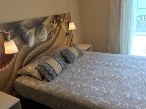 ein Schlafzimmer mit einem Bett mit zwei Kissen darauf in der Unterkunft Apartamento frente al mar in San Pedro