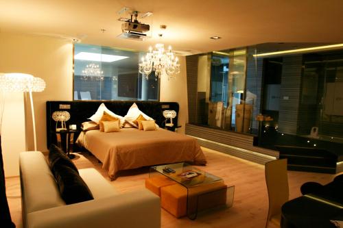 een slaapkamer met een bed, een bank en een kroonluchter bij Kadrit Hotel in Cadrete