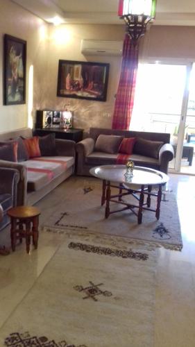 a living room with a couch and a coffee table at Perle de Tamaris in Dar Bouazza