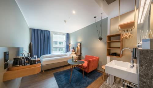Habitación de hotel con cama, escritorio y lavabo. en Hotel Ploberger en Wels