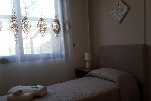 a bedroom with a bed and a window at Demetra Malophoros in Marinella di Selinunte