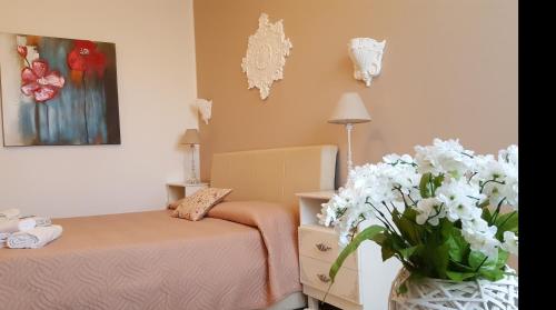 a bedroom with a bed and a vase of flowers at Demetra Malophoros in Marinella di Selinunte