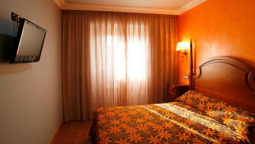 a hotel room with a bed and a window at Hostal Victoria I in Madrid