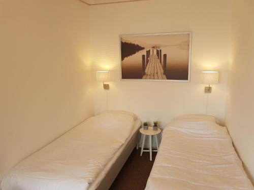 two beds in a room with a picture on the wall at Klintholm Marina Park Cabins in Borre