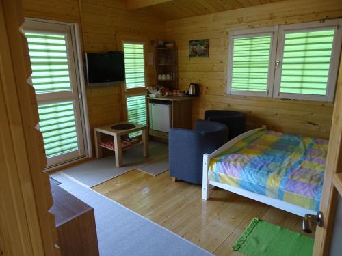 1 dormitorio con 1 cama en una cabaña de madera en Lesny domek, en Międzyzdroje