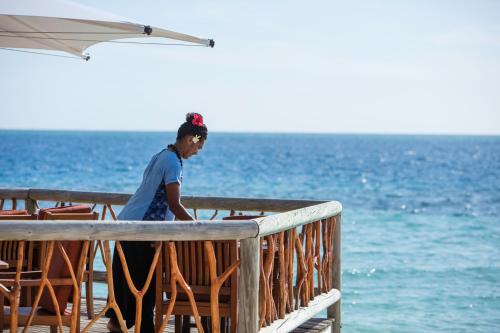 a woman standing on a deck looking at the ocean at Castaway Island, Fiji in Castaway Island