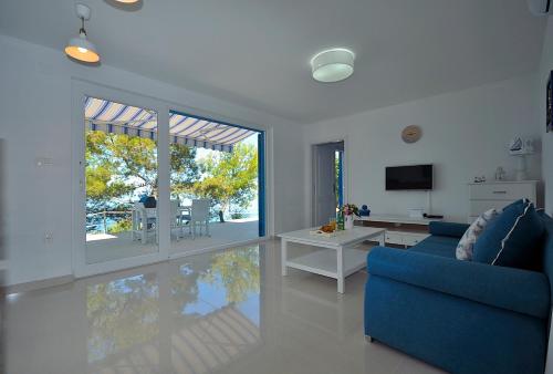 uma sala de estar com um sofá azul e uma televisão em Apartment Sunset em Primošten