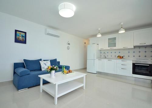 uma sala de estar com um sofá azul e uma mesa em Apartment Sunset em Primošten