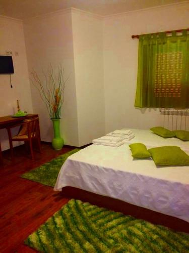 a bedroom with a bed with green pillows on it at Casa d'Avó Faia in Morais