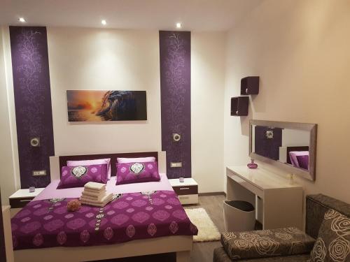 ein Schlafzimmer mit einem lila Bett und einem Spiegel in der Unterkunft Apartment Adis in Šibenik