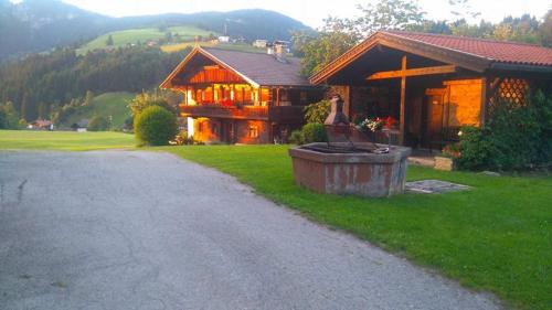 a house with a water fountain in front of it at Schwaighof in Oberau