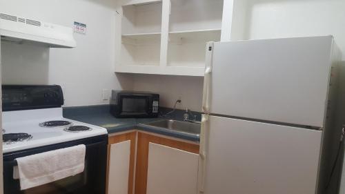 uma cozinha com um frigorífico branco e um lavatório em Monte Carlo Motel em Nova Orleães