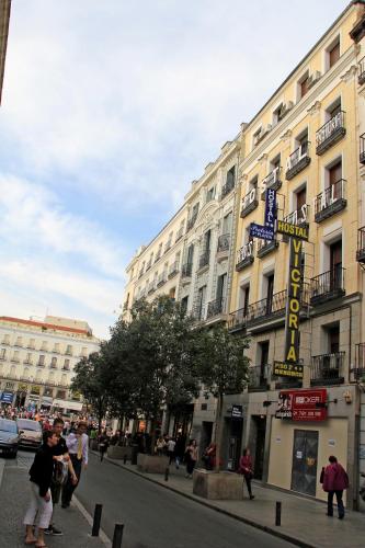 a building with a hotel sign on a city street at Hostal Victoria I in Madrid
