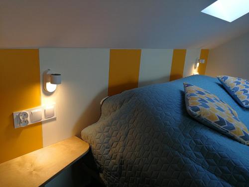 a bedroom with a blue bed and a wooden table at Kasztanowe Wrota in Kosewo