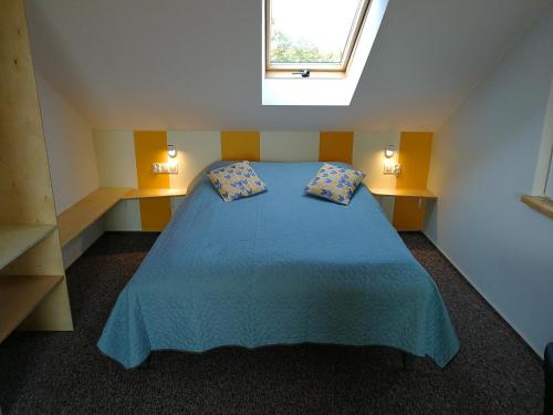 a bedroom with a blue bed with two pillows at Kasztanowe Wrota in Kosewo