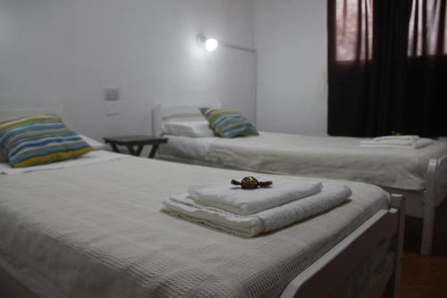 two beds with towels on them in a room at Hotel Vuelta del Ombu in Gobernador Ingeniero Valentín Virasoro