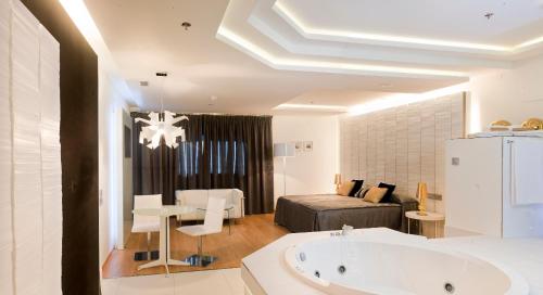 a bathroom with a bath tub and a bedroom at Kadrit Hotel in Cadrete