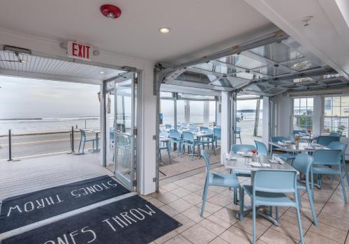 a restaurant with blue chairs and tables and the beach at Stones Throw in York Beach