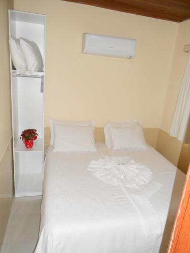 a white bed with white sheets and pillows at Hotel SESI Valença in Valença