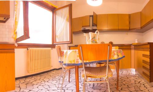 a kitchen with a table and chairs in it at Balcon des Alpes in Teglio
