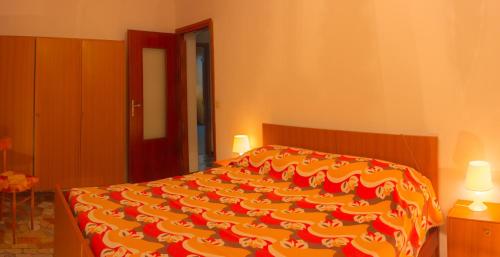 テーリオにあるCulla alpina 3°pianoのベッドルーム1室(赤と黄色の毛布付きのベッド1台付)