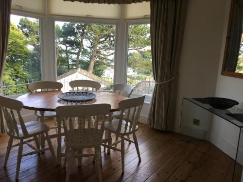 a dining room with a table and chairs and a window at Moult Sylvan in Salcombe