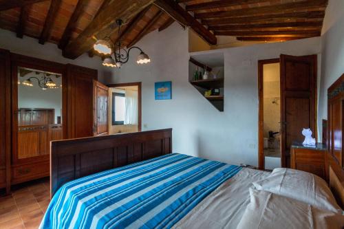 um quarto com uma cama com lençóis listrados em azul e branco em ART REBUS Tower in Tuscany em Radda in Chianti