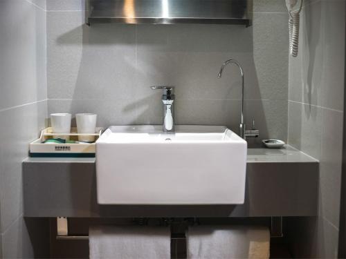 a bathroom with a white sink in a room at Home Inn Selected Nanjing Xuanwu Lake New Model Road Subway Station in Nanjing