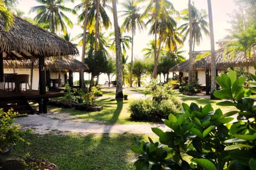 a view of a resort with palm trees at Tamanu Beach in Arutanga