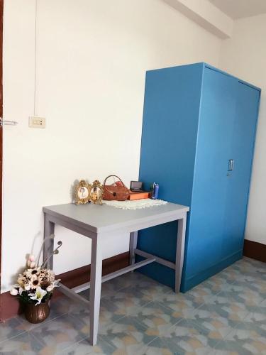 a table and a blue cabinet in a room at Chanathinat Place in Udon Thani