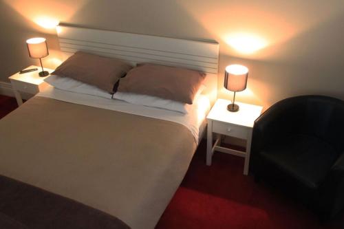 a bedroom with a white bed with two lamps on it at Sporties Hotel in Launceston