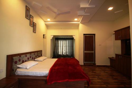 um quarto com uma cama com um cobertor vermelho em Goflamingo Resort em Silāri