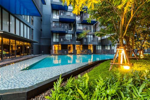 a swimming pool in front of a building at The Deck Condominium by Lofty in Patong Beach